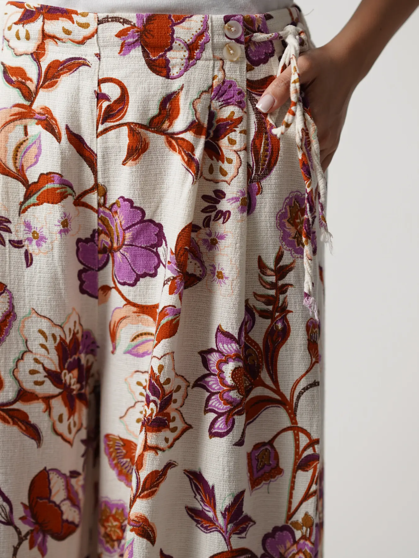 شلوار شیری بنفش طرح گل و برگ کمربندگره ای 